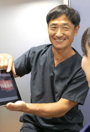 歯科用マイクロスコープを使用して診療する歯科医師